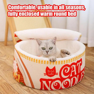 A gray cat lounges in the KittyNook Cat Co. Cute Ramen Cat Bed, shaped like noodles with a soft, open lid.